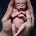 Life size clay portrait of a baby at 20 weeks of life-Clay sculpt in my husbands hands